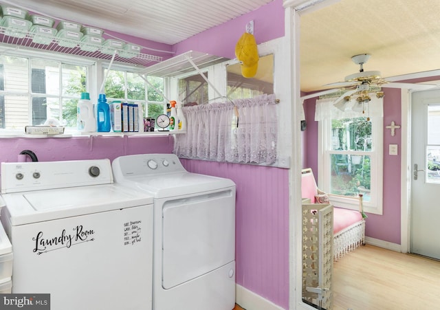 clothes washing area with ceiling fan, washing machine and clothes dryer, and light hardwood / wood-style flooring