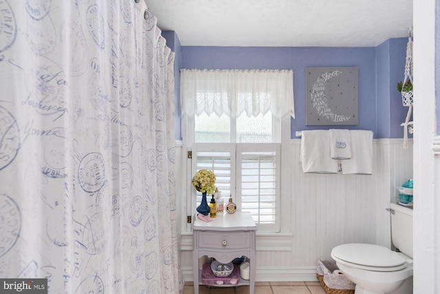 bathroom with vanity, plenty of natural light, toilet, and tile patterned flooring