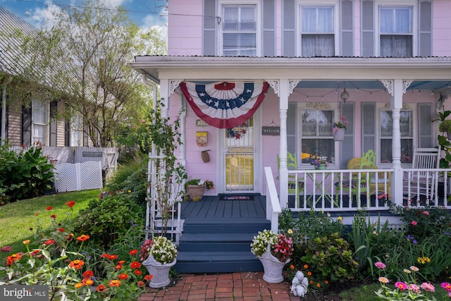 view of exterior entry featuring covered porch