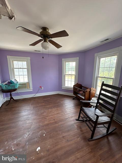 sitting room featuring cooling unit, dark wood-type flooring, ceiling fan, and a healthy amount of sunlight