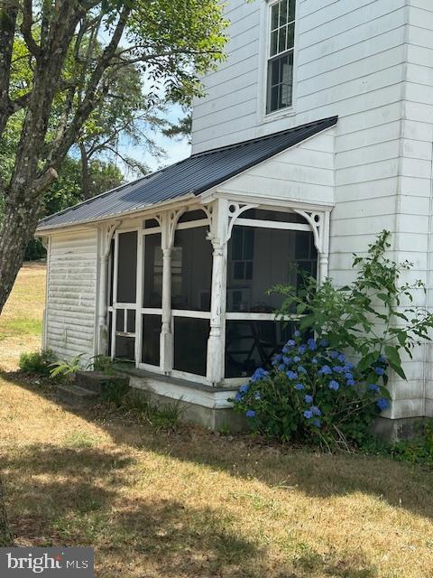 view of side of property with a lawn and a sunroom