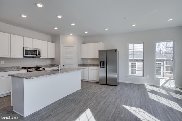 kitchen with a kitchen island with sink, sink, white cabinets, and stainless steel appliances