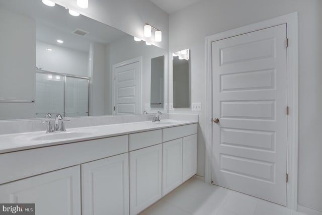 bathroom with tile patterned flooring, vanity, and walk in shower