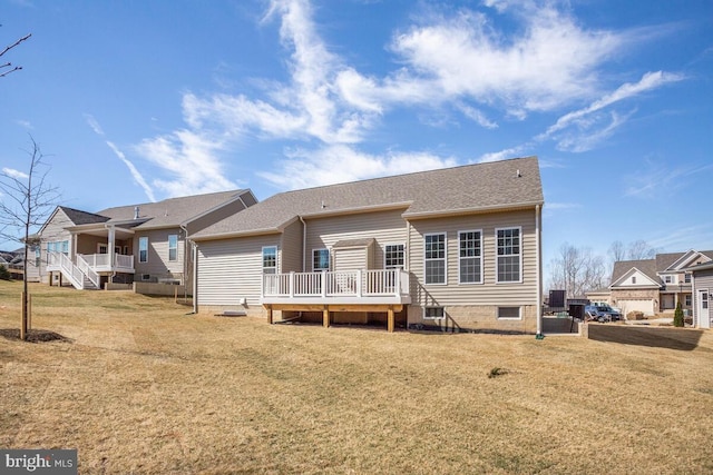 rear view of house featuring a lawn and a deck