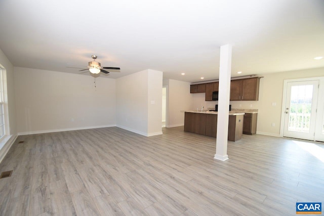 unfurnished living room with ceiling fan and light hardwood / wood-style floors