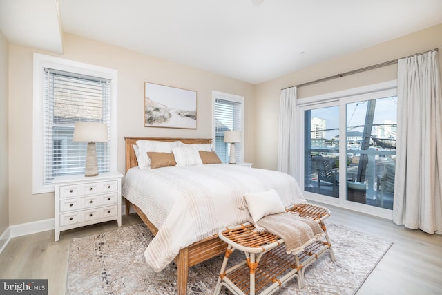 bedroom with access to exterior and light wood-type flooring