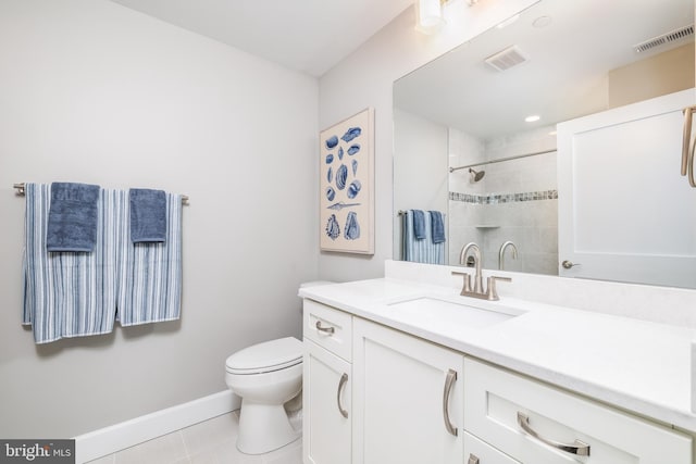 bathroom with tile patterned floors, vanity, a tile shower, and toilet