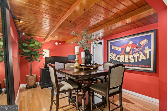 dining space featuring beamed ceiling and light hardwood / wood-style floors