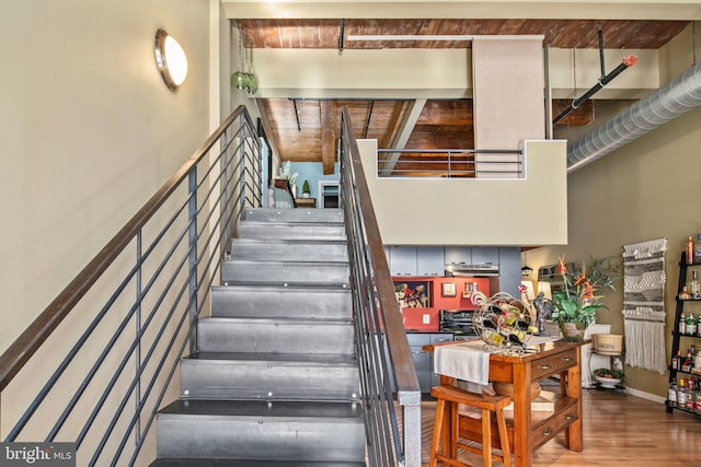 staircase featuring wood-type flooring and wooden ceiling