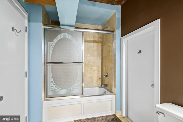 bathroom with tile patterned floors, toilet, and enclosed tub / shower combo