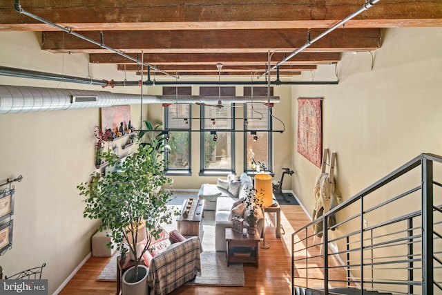 unfurnished living room featuring beam ceiling and wood-type flooring