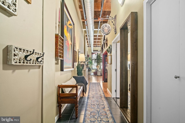 hallway featuring dark tile patterned floors