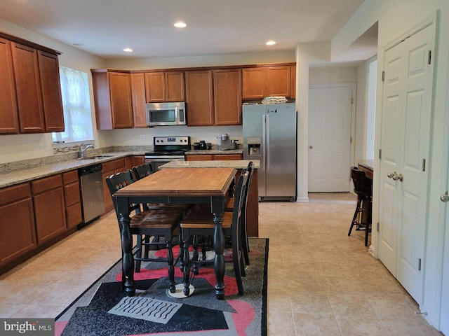 kitchen with light stone countertops, sink, and stainless steel appliances