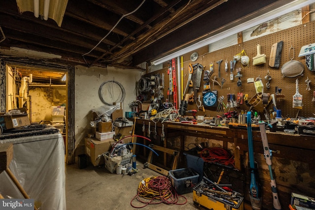 miscellaneous room with a workshop area, washer / dryer, and concrete floors