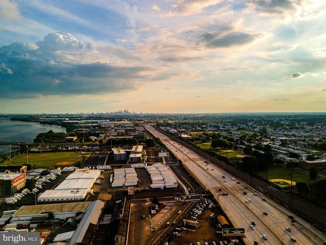 aerial view at dusk featuring a water view