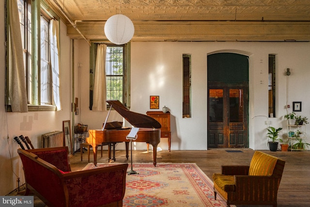 sitting room featuring radiator heating unit and hardwood / wood-style flooring