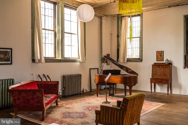 sitting room with radiator heating unit, hardwood / wood-style flooring, and a wealth of natural light