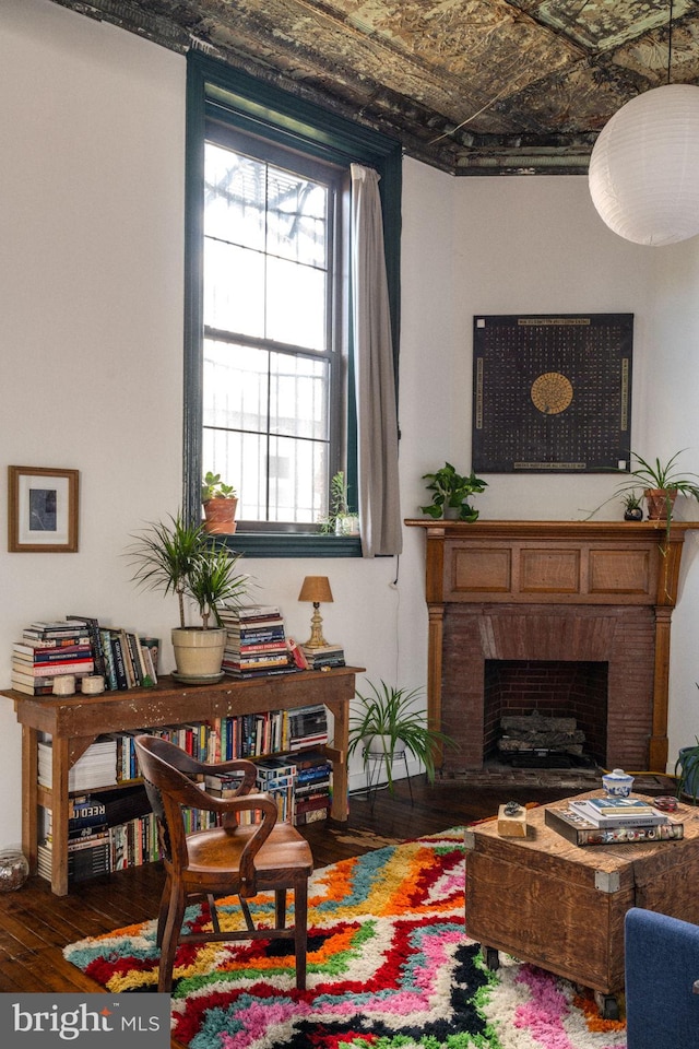 sitting room with a fireplace and hardwood / wood-style flooring