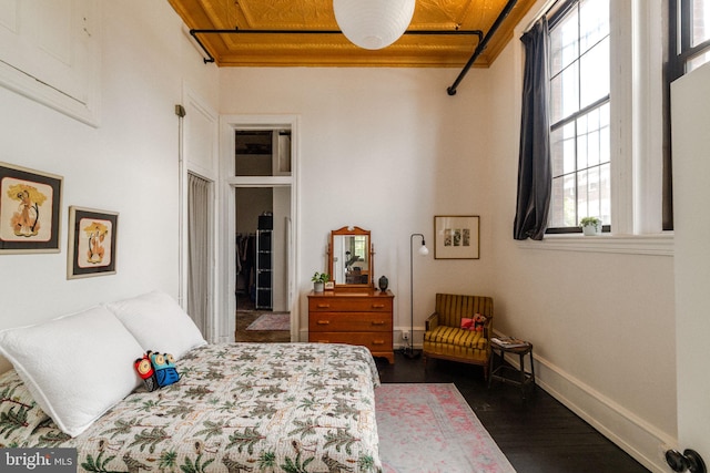 bedroom with dark hardwood / wood-style floors, multiple windows, and wood ceiling