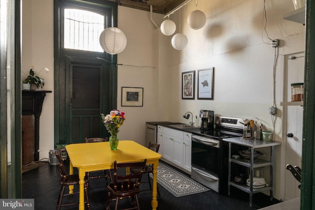 kitchen with white cabinets, dark hardwood / wood-style floors, stainless steel electric stove, and sink