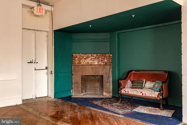 living area featuring hardwood / wood-style floors and a brick fireplace