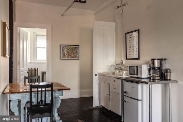 interior space featuring sink, dark hardwood / wood-style floors, and radiator heating unit