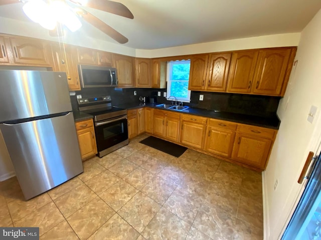 kitchen featuring decorative backsplash, sink, ceiling fan, and appliances with stainless steel finishes