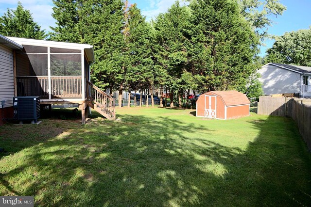 view of yard with central AC unit and a storage shed