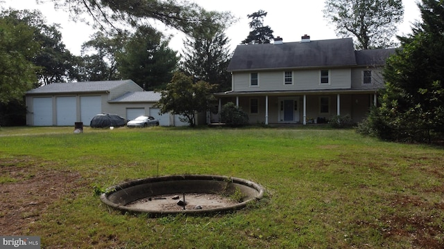 61AND63 Dune Dr, North East, MD 21901 - view of front of home featuring an outdoor fire pit, a detached garage, a chimney, covered porch, and a front lawn
