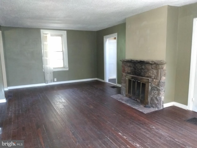61AND63 Dune Dr, North East, MD 21901 - unfurnished living room with visible vents, a textured ceiling, a stone fireplace, wood finished floors, and baseboards