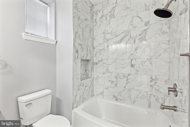 bathroom with tiled shower / bath combo and toilet