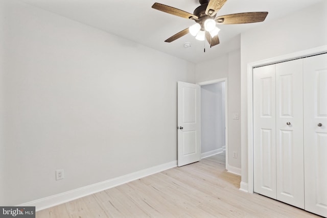 unfurnished bedroom with ceiling fan, a closet, and light hardwood / wood-style floors