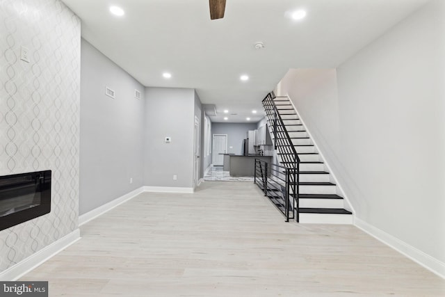 interior space featuring a fireplace, hardwood / wood-style flooring, and ceiling fan