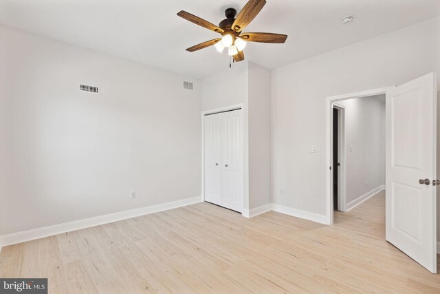 unfurnished bedroom featuring light wood-type flooring, a closet, and ceiling fan