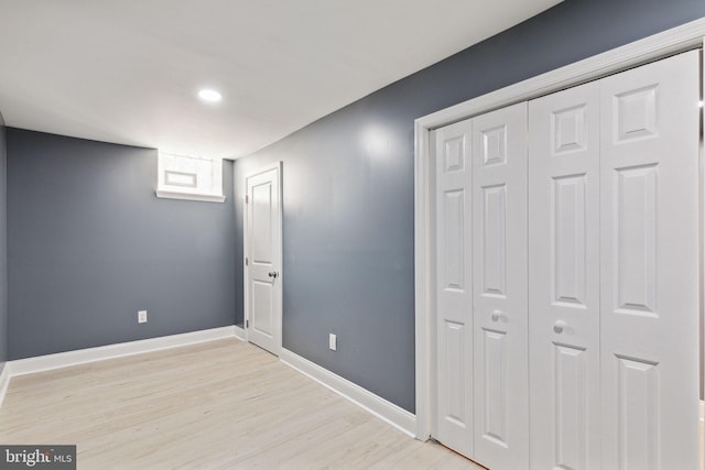 unfurnished bedroom with a closet and light wood-type flooring