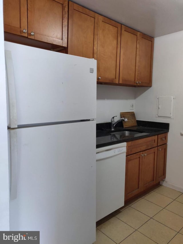 kitchen featuring light tile patterned flooring, white appliances, and sink