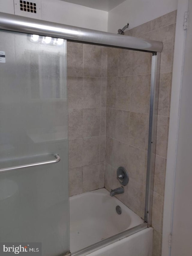 bathroom with shower / bath combination with glass door