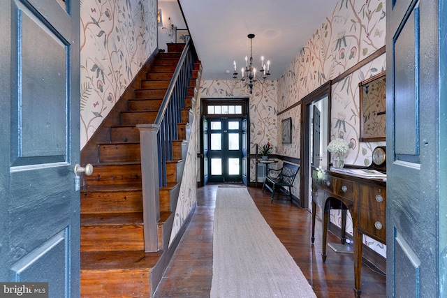 foyer entrance featuring a chandelier and dark wood-type flooring