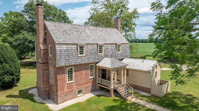 rear view of property with a lawn