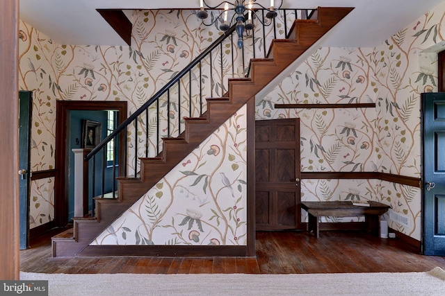 staircase featuring hardwood / wood-style floors and a chandelier