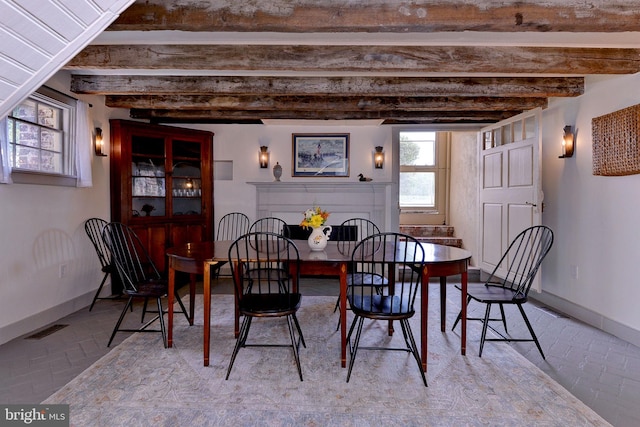 dining area featuring beamed ceiling