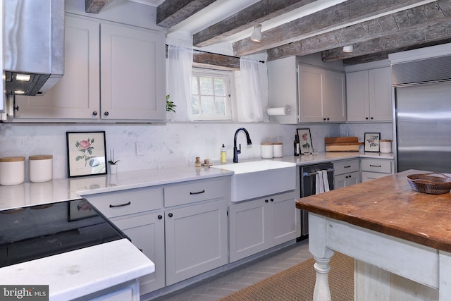 kitchen featuring tasteful backsplash, gray cabinetry, sink, and appliances with stainless steel finishes