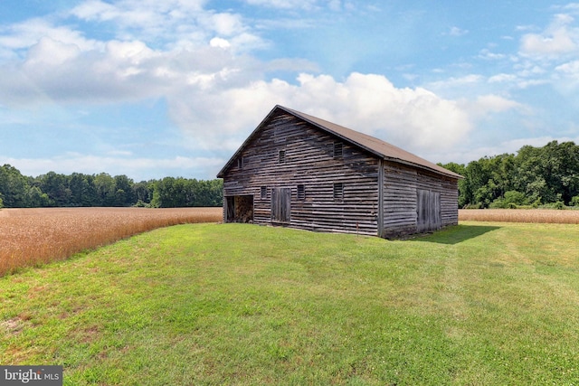 view of side of property with a lawn and an outbuilding