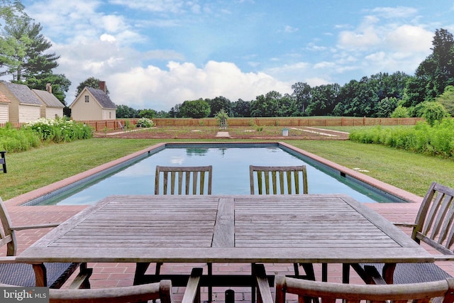 view of pool with a lawn