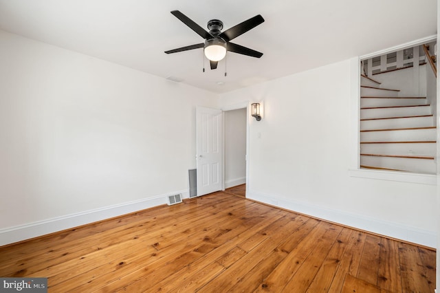 empty room with hardwood / wood-style floors and ceiling fan