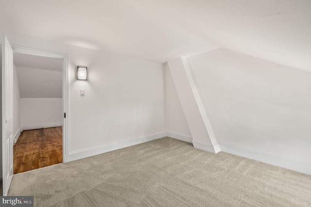 additional living space with light colored carpet and lofted ceiling