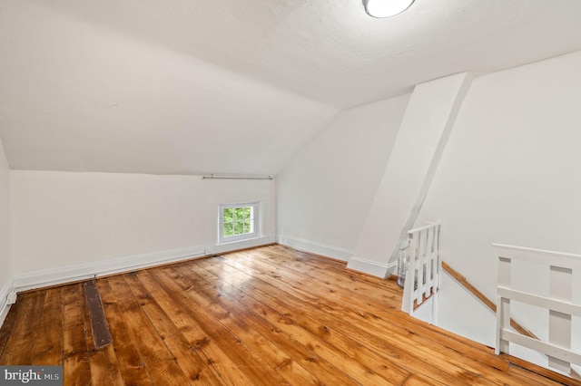 bonus room with light hardwood / wood-style floors and vaulted ceiling