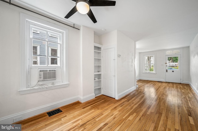 interior space with ceiling fan, cooling unit, and light wood-type flooring