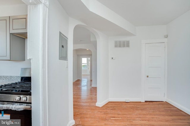 corridor featuring electric panel and light hardwood / wood-style flooring