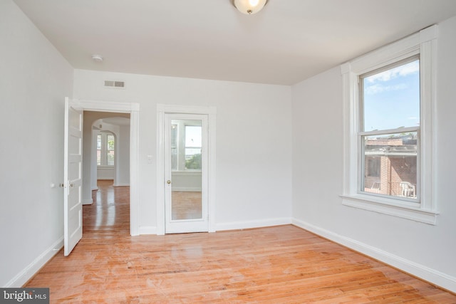 spare room featuring a healthy amount of sunlight and light hardwood / wood-style floors